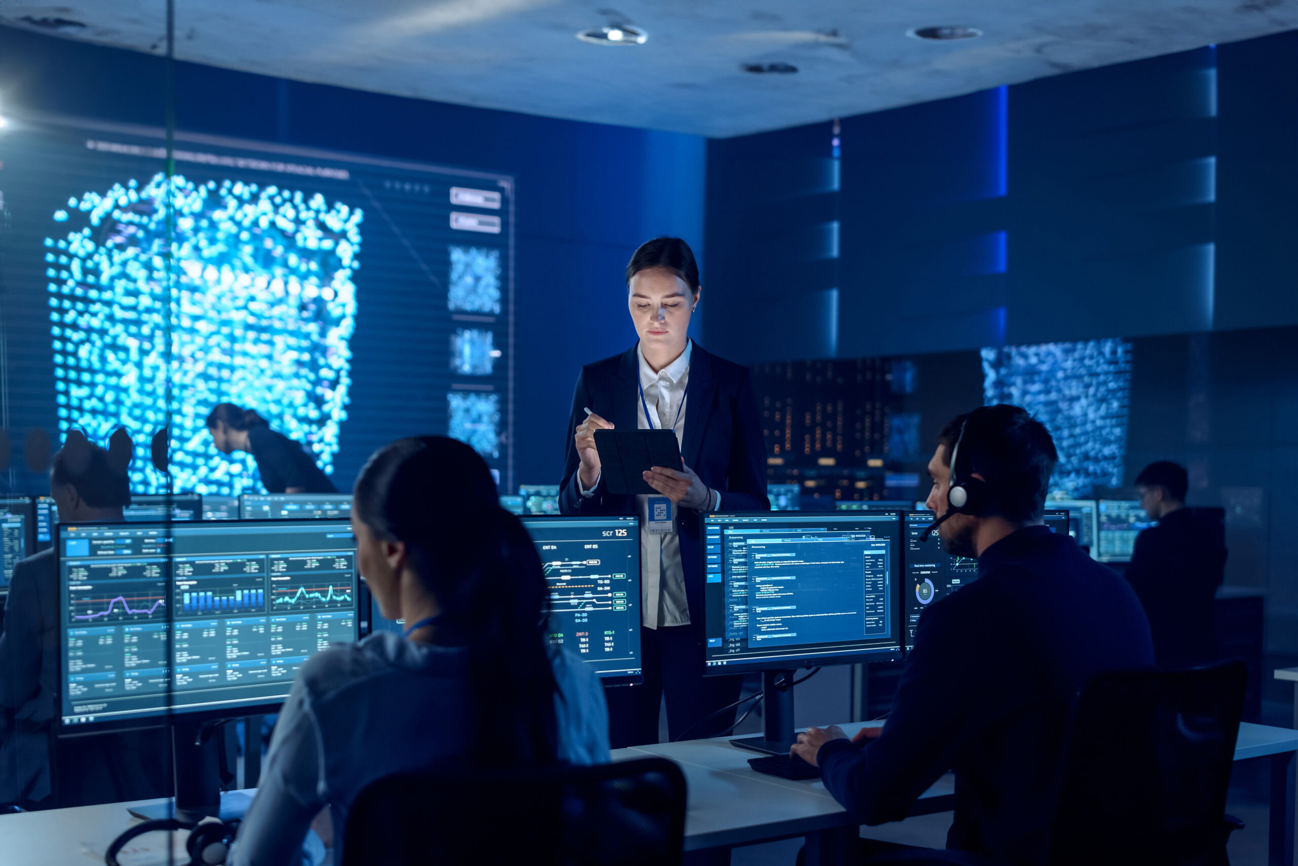 Team analyzing data in high-tech control room.